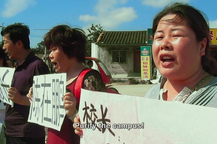 We meet Ye Haiyan and the other activists and see them protest outside the school.