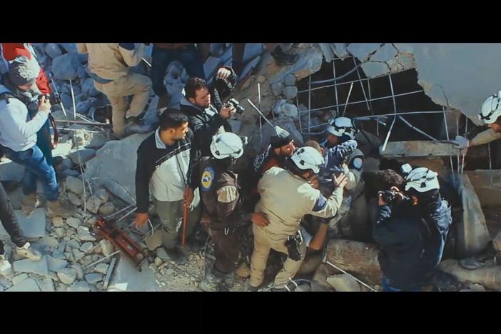 We see Mahmoud dig out three children from underneath bombed-out rubble.