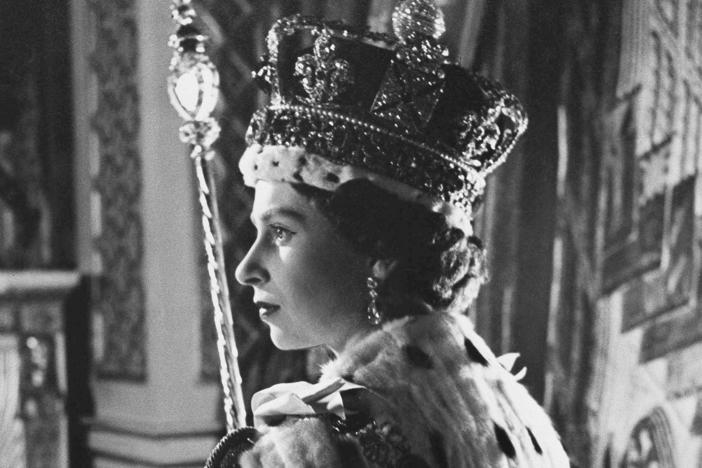 Queen Elizabeth II poses in her coronation attire in the throne room of Buckingham Palace in London, after her coronation on June 2, 1953.