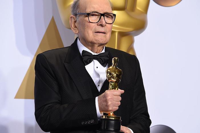 Composer Ennio Morricone, posing with his Oscar for <em>The Hateful Eight </em>in 2016. He died Monday at age 91 in Rome.