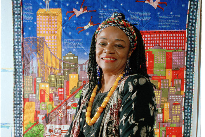 Artist Faith Ringgold sits before her quilt "Tar Beach" in 1993. <em></em>The artwork also inspired a children's book of the same name.
