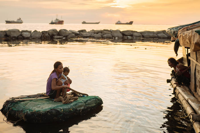 Joan Garcia became pregnant at 14 and gave birth at 15. She and her child travel by raft between the two shacks where they live in Navotas fish port on Manila Bay.