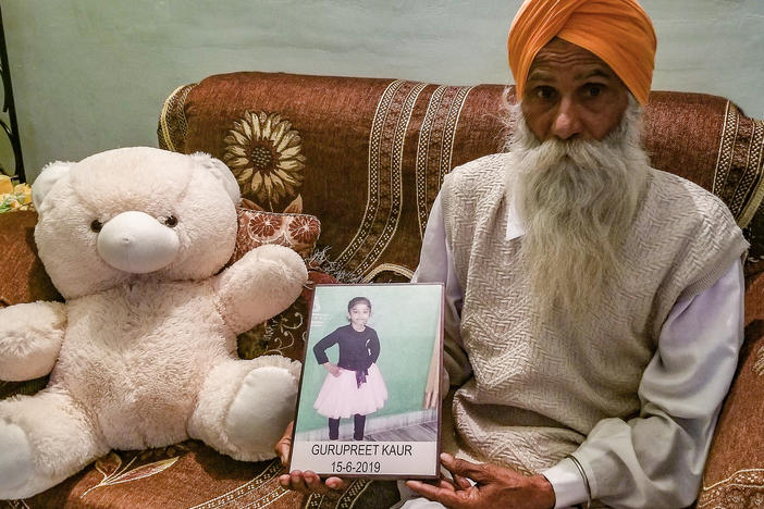 Gurmeet Singh holds a photo of his granddaughter, Gurupreet Kaur, who died of heatstroke in Arizona in June 2019. The 6-year-old and her mother had just crossed into the U.S. from Mexico.