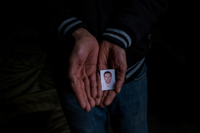 Jilani Hablani holds a portrait of his son, Abdelwaheb Hablani, at his home in Jelma, Tunisia. In December 2019, Abdelwaheb Hablani, 25, self-immolated and died. He was working as a day laborer but had not been paid in nearly two years.