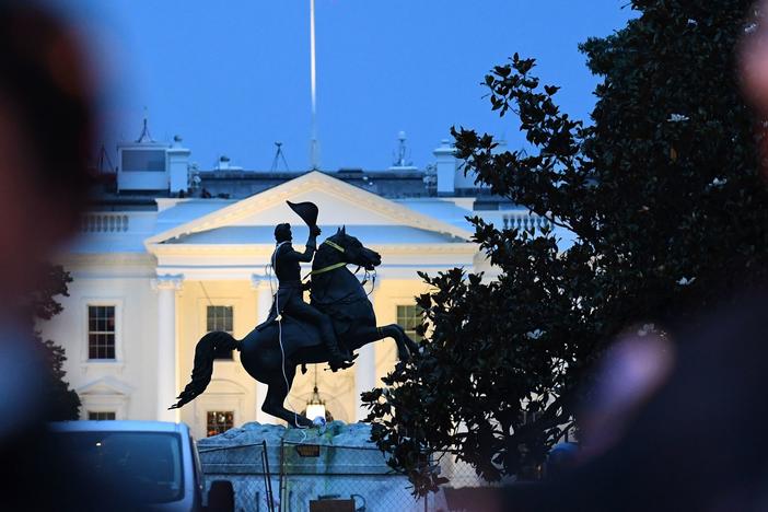 Police officers stand guard with the statue of former President Andrew Jackson after protesters tried to topple it Monday in Lafayette Square in Washington, D.C.