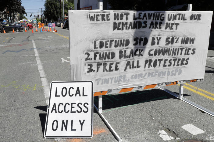 The Seattle Police Department will return to their East Precinct building "in the near future," Mayor Jenny Durkan says. Here, a sign on a street barricade lists protesters' demands in the Capitol Hill Occupied Protest zone, where two shootings took place over the weekend.
