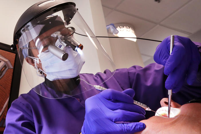 Dental offices have begun seeing patients return for routine procedures. Seattle dentist Kathleen Saturay has increased the layers of protective equipment she wears when treating patients.