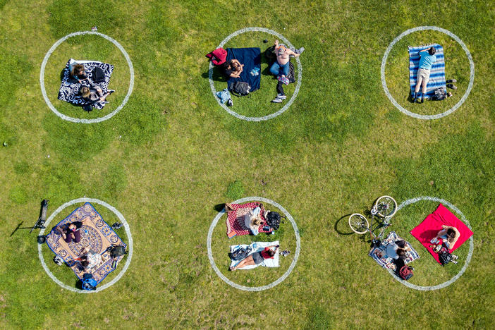 Communication skills used to negotiate safe sex are also useful for setting boundaries while socializing during the COVID-19 pandemic. Above, circles drawn in the grass encourage social distancing at Dolores Park in San Francisco.