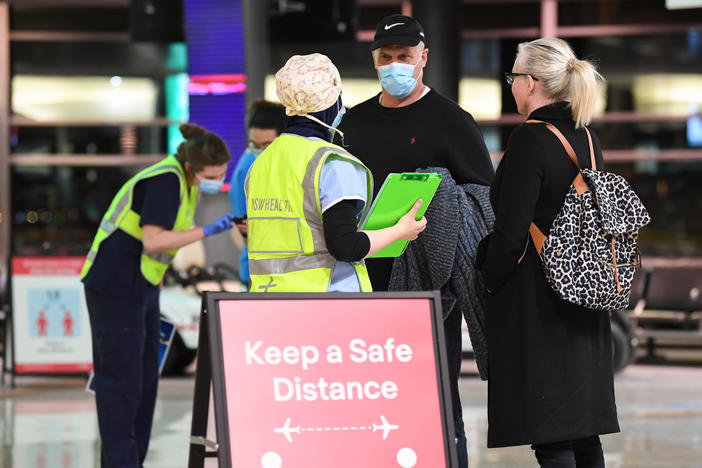 New South Wales health officials interview passengers as they arrive from a Qantas flight that flew from Melbourne at Sydney Airport in July.