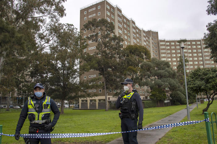 Police guard access to housing commission apartments under lockdown in Melbourne, Australia. The hard-hit Australian state of Victoria recorded two deaths and its highest-ever daily increase in coronavirus cases on Monday as authorities prepare to close its border with New South Wales.