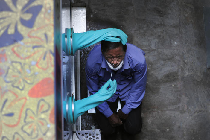 A health worker takes a nasal swab for COVID-19 at a hospital in New Delhi. India has overtaken Russia to become the third-worst coronavirus affected nation.