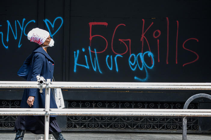 A pedestrian walks past anti-5G graffiti in the Flatiron District of New York in May.
