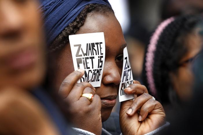 A demonstrator holds a sign reading "Black Pete Is Racism" during a 2013 demonstration in Amsterdam. Zwarte Piet or Black Pete is traditionally depicted by white people wearing blackface, Afro wigs and red lipstick.