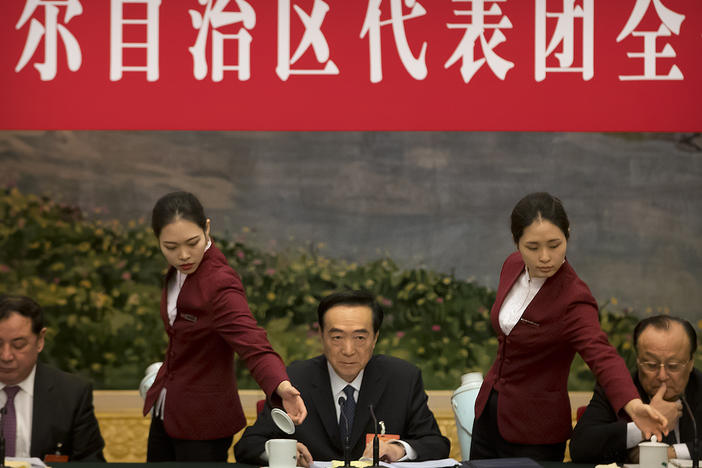 Attendants refill teacups as Chen Quanguo (center), Communist Party secretary of China's Xinjiang Uighur Autonomous Region, listens to a speaker during a group discussion meeting on the sidelines of the National People's Congress at the Great Hall of the People in Beijing, on March 12, 2019. The Politburo member is one of the subjects of new U.S. sanctions over human rights abuses in the region.