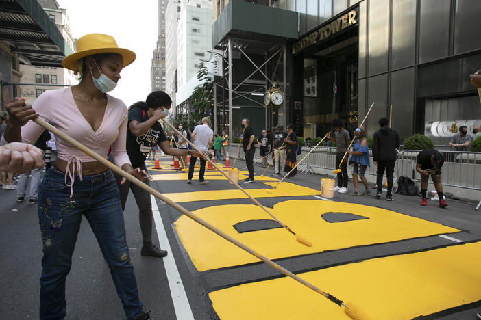 Azia Toussaint helps paint a Black Lives Matter mural on Fifth Avenue in front of Trump Tower on Thursday in New York.