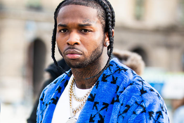 Los Angeles police say they have arrested five people in connection with the February shooting death of rapper Pop Smoke. The late musician is seen here during Paris Fashion Week's men's fall-winter shows in January.