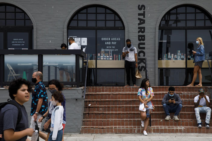 People gathered outside of a Starbucks coffee shop at Venice Beach in Los Angeles last month. The company's order for all customers to wear masks will take effect on July 15.