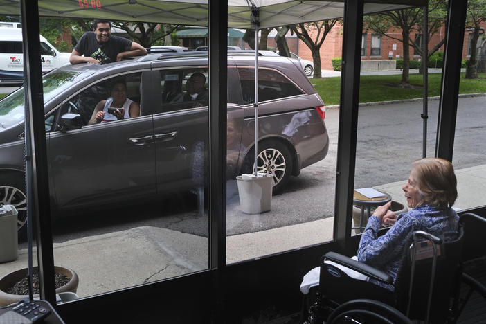Gloria DeSoto, 92, right, visits with her family, in their car, from a window of the Hebrew Home at Riverdale, in New York, last month.