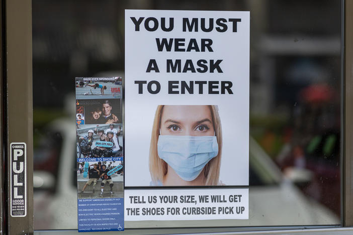 Masks are required for entry to a shoe store in Glendale, Calif. Most people follow guidelines to wear masks when they enter retail stores and restaurants, but some customers don't comply.