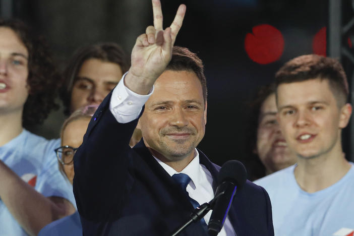 Presidential candidate and Warsaw Mayor Rafal Trzaskowski flashes a victory sign at the end of election day in Warsaw.