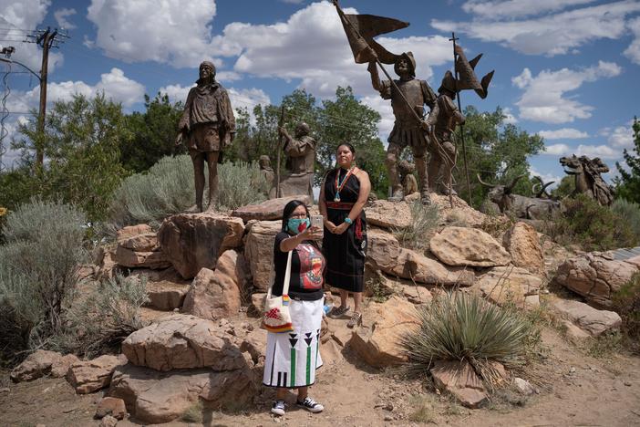 Channing Concho, left, and American Horse photograph themselves in front of a memorial after a sculpture of Spanish conquistador Juan de Onate was removed on June 16, 2020 in Albuquerque.