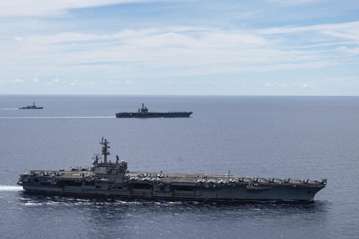 The USS Ronald Reagan (foreground) and the USS Nimitz Carrier Strike Groups sail together in formation in the South China Sea on July 6. China has accused the U.S. of flexing its military muscles by conducting joint exercises with two U.S. aircraft carrier groups in the strategic waterway.