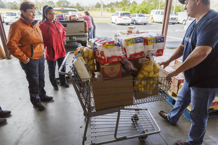 Douglas Griner, right, partner services director of the Second Harvest of South Georgia food bank in Valdosta, loads up food for three TSA workers Thursday morning.