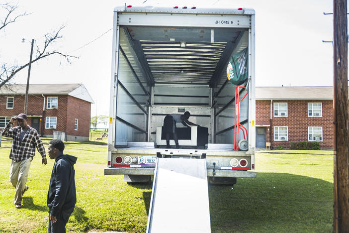 Kenny Howell Jr. slides his sofa into place in the back of a moving truck on the Wednesday he picked to move himself, his girlfriend and their three kids from the Tindall Heights Housing Project to a new rental house. 