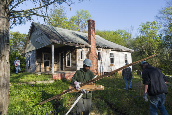 A crew works to demolish a home in Macon's Linwood Estates neighborhood in 2015. The original, Federal redlining maps from the 1930s said of Linwood "subdivision failed before depression began."