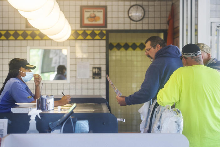 Diners place a takeout order inside a Macon Waffle Hosue on the first day restaurants were open to dine-in customers again during the coronavirus pandemic.