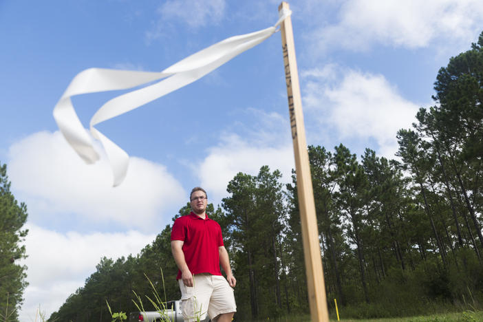 James "Jeb" Bell points out the flags that cross his land in Mitchell County. They mark the path of Sabal Trail pipeline.