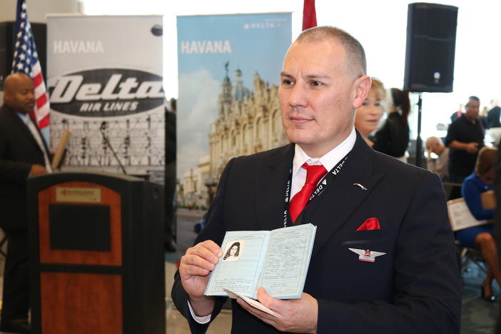 In-flight service manager Robert Cisneros holds his mothers passport before boarding one of three inaugural Delta operated flights to Havana, Cuba, Thursday, Dec. 1, 2016, in Atlanta, Georgia. 