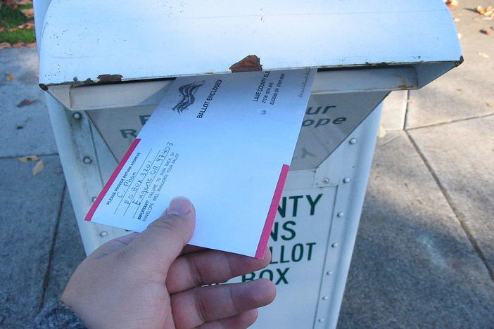 A voter returns his vote-by-mail ballot in Lane County, Oregon