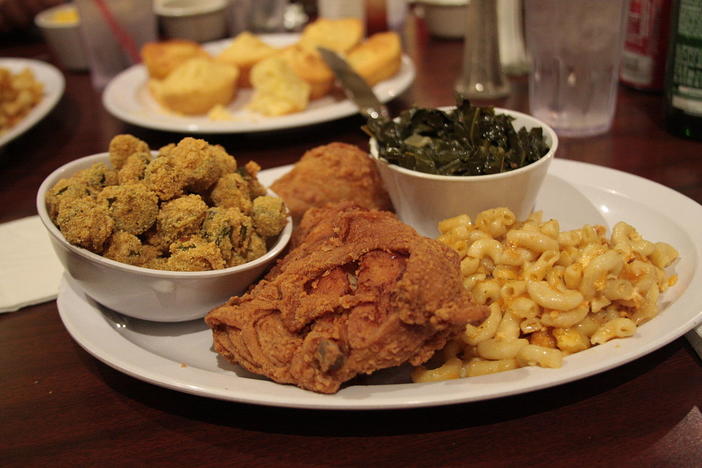  A traditional soul food dinner consisting of fried chicken with macaroni and cheese, collard greens, breaded fried okra and cornbread.