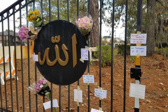 Flowers and notes of support hang on the fence of the Islamic Center of Savannah.