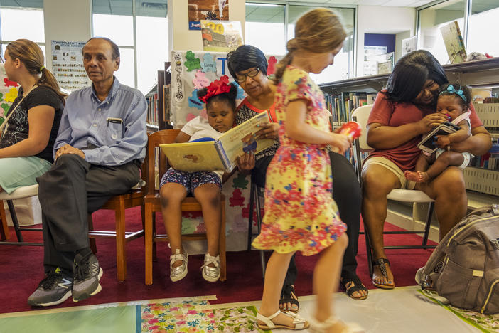 Johnnie Prater, center, reads to her granddaughter at the Riverside Library in Macon Friday. 