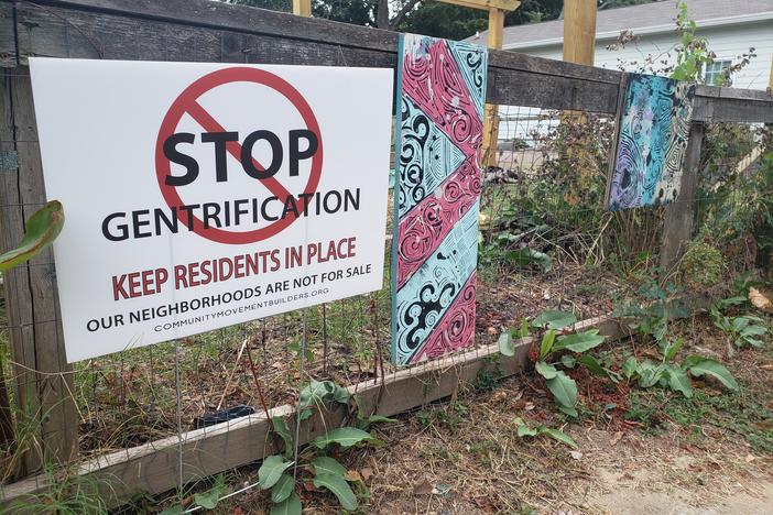 A sign sits outside of Welch Park in Atlanta calling for an end to gentrification. It was placed by an anti-gentrification group, Community Movement Builders.