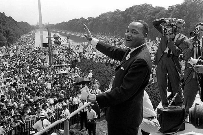 Historic photo of Martin Luther King Jr. addressing a crowd at Washington Monument.
