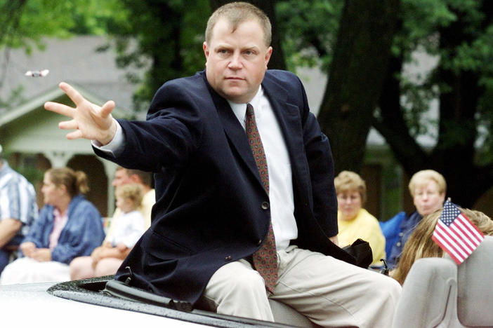 Richard Jewell, parade grand marshal, tosses candy to spectators along the parade route in Carmel, Ind., in 2001. Jewell, who was the focus of an FBI investigation for the 1996 Olympic Park bombing, was being honored as one of the nation's unsung heroes. 