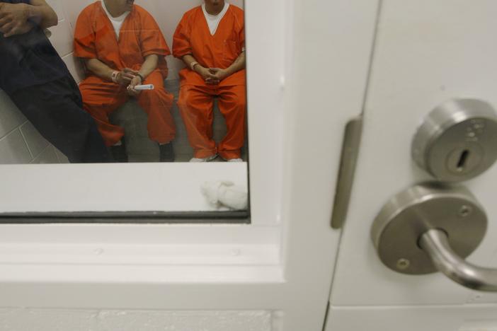 In this photo taken on Friday, Oct. 17, 2008, detainees are shown inside a holding cell at the Northwest Detention Center in Tacoma, Wash. The facility is operated by The GEO Group Inc. under contract from U.S. Immigrations and Customs Enforcement.