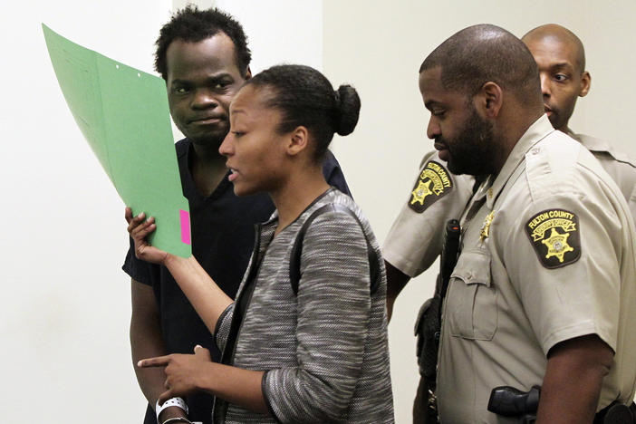 Basil Eleby is escorted by his public defender and two Fulton County Sheriff's office officers into the court room at the Fulton County Jail in Atlanta on Saturday, April 1, 2017.