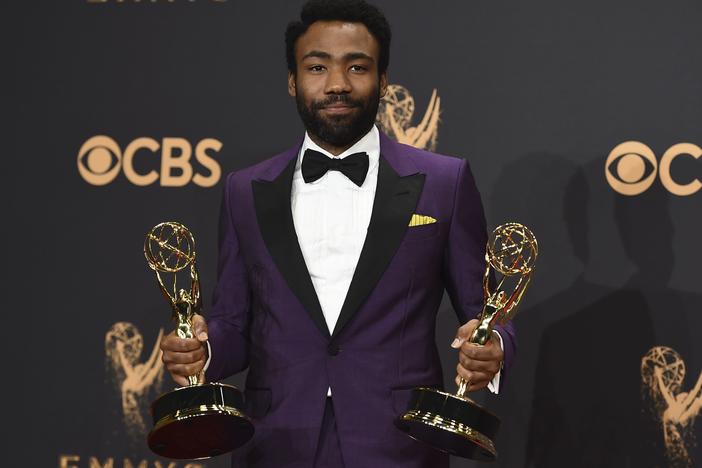 Donald Glover poses in the press room with his awards for outstanding lead actor in a comedy series and for outstanding directing for a comedy series for "Atlanta" at the 69th Primetime Emmy Awards on Sunday, Sept. 17, 2017.