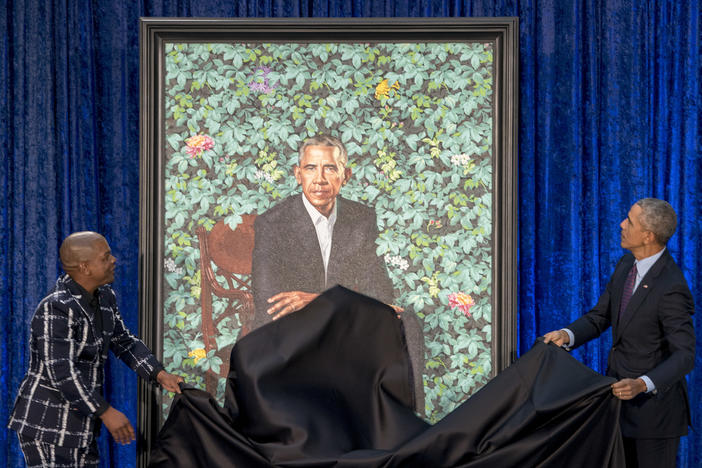 Former President Barack Obama, right, and Artist Kehinde Wiley, left, unveil Obama's official portrait at the Smithsonian's National Portrait Gallery, Monday, Feb. 12, 2018, in Washington.