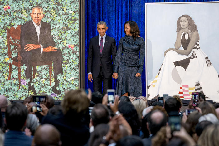 Former President Barack Obama and former first lady Michelle Obama stand on stage as their official portraits are unveiled at a ceremony at the Smithsonian's National Portrait Gallery, Monday, Feb. 12, 2018, in Washington.