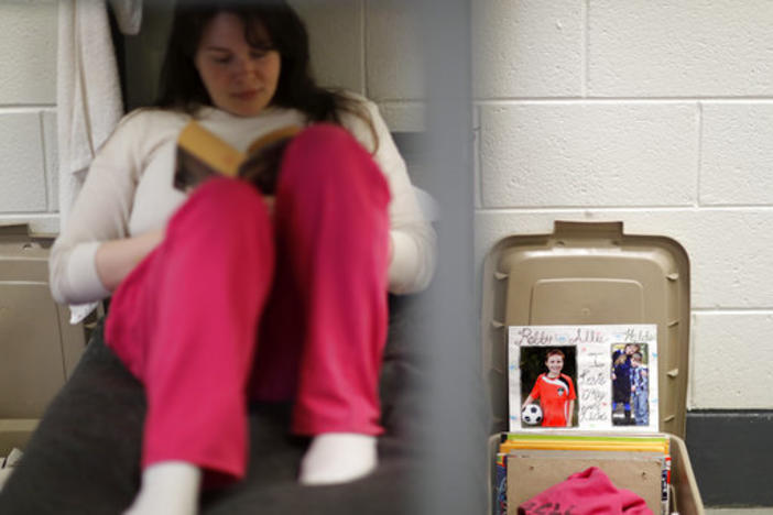 An inmate reads in her bed.