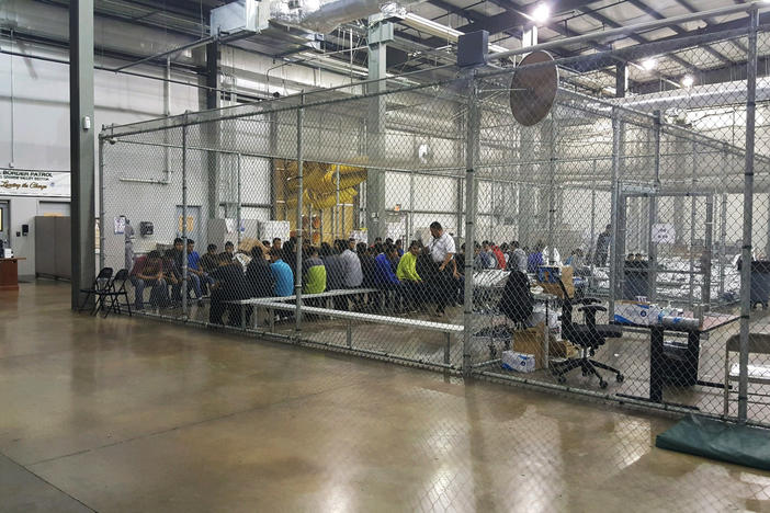 In this photo provided by U.S. Customs and Border Protection, people who've been taken into custody related to cases of illegal entry into the United States, sit in one of the cages at a facility in McAllen, Texas, Sunday, June 17, 2018.