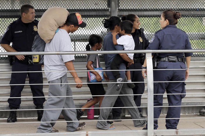 Ever Castillo, left, and his family, immigrants from Honduras, are escorted back across the border by U.S. Customs and Border Patrol agents Thursday, June 21, 2018, in Hildalgo, Texas. 