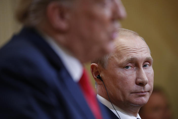 Russian President Vladimir Putin looks over towards U.S. President Donald Trump as Trump speaks during their joint news conference at the Presidential Palace in Helsinki, Finland.