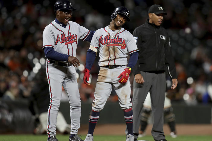 Atlanta Braves shortstop Ozzie Albies (1) and Atlanta Braves third base coach Ron Washington (37) smile after Albies doubled and advanced to third on a throwing error by Gorkys HernÃ¡ndez in the seventh inning of a baseball game in San Francisco.