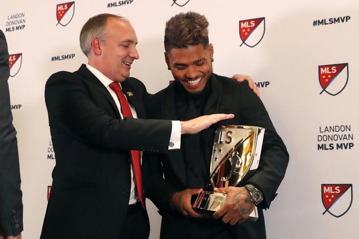 Josef Martinez laughs with Atlanta United President Darren Eales after receivng the MVP trophy.